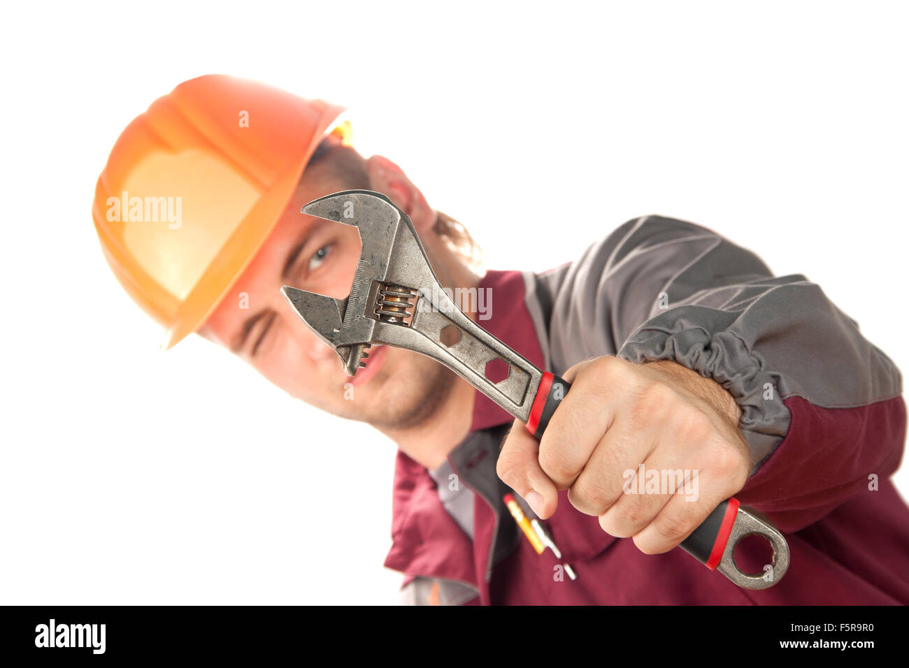 Uomo di lavoro con una chiave regolabile. Isolato su bianco Foto Stock