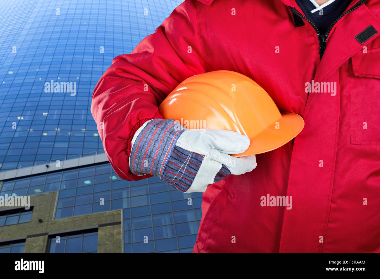 Lavoratore azienda hardhat contro l edificio per uffici Foto Stock