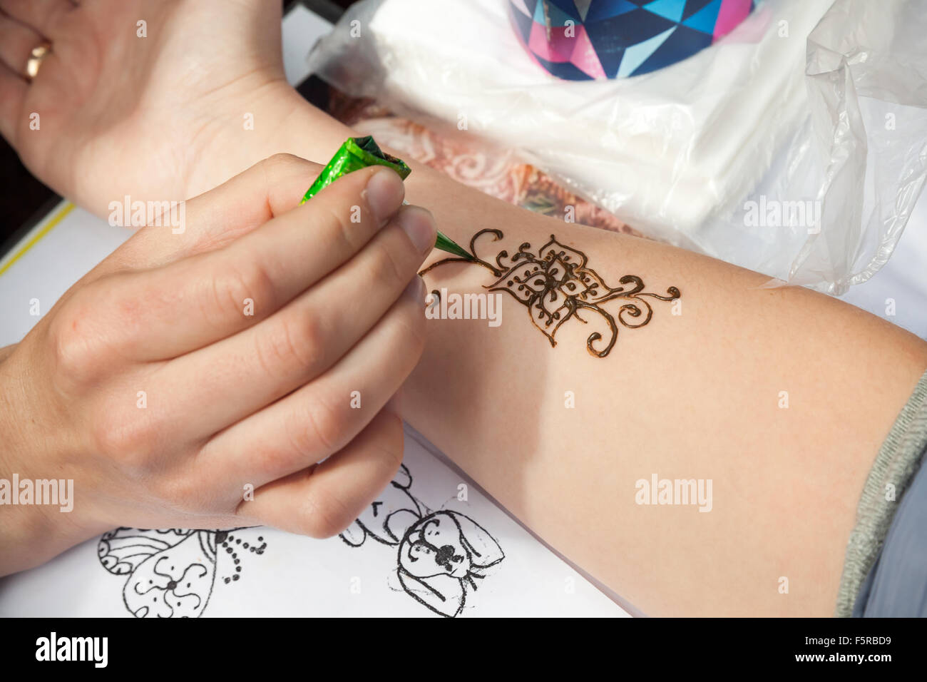 San Pietroburgo, Russia - Luglio 19, 2015: Brown henna pasta o mehndi applicazione sulla donna mano Foto Stock