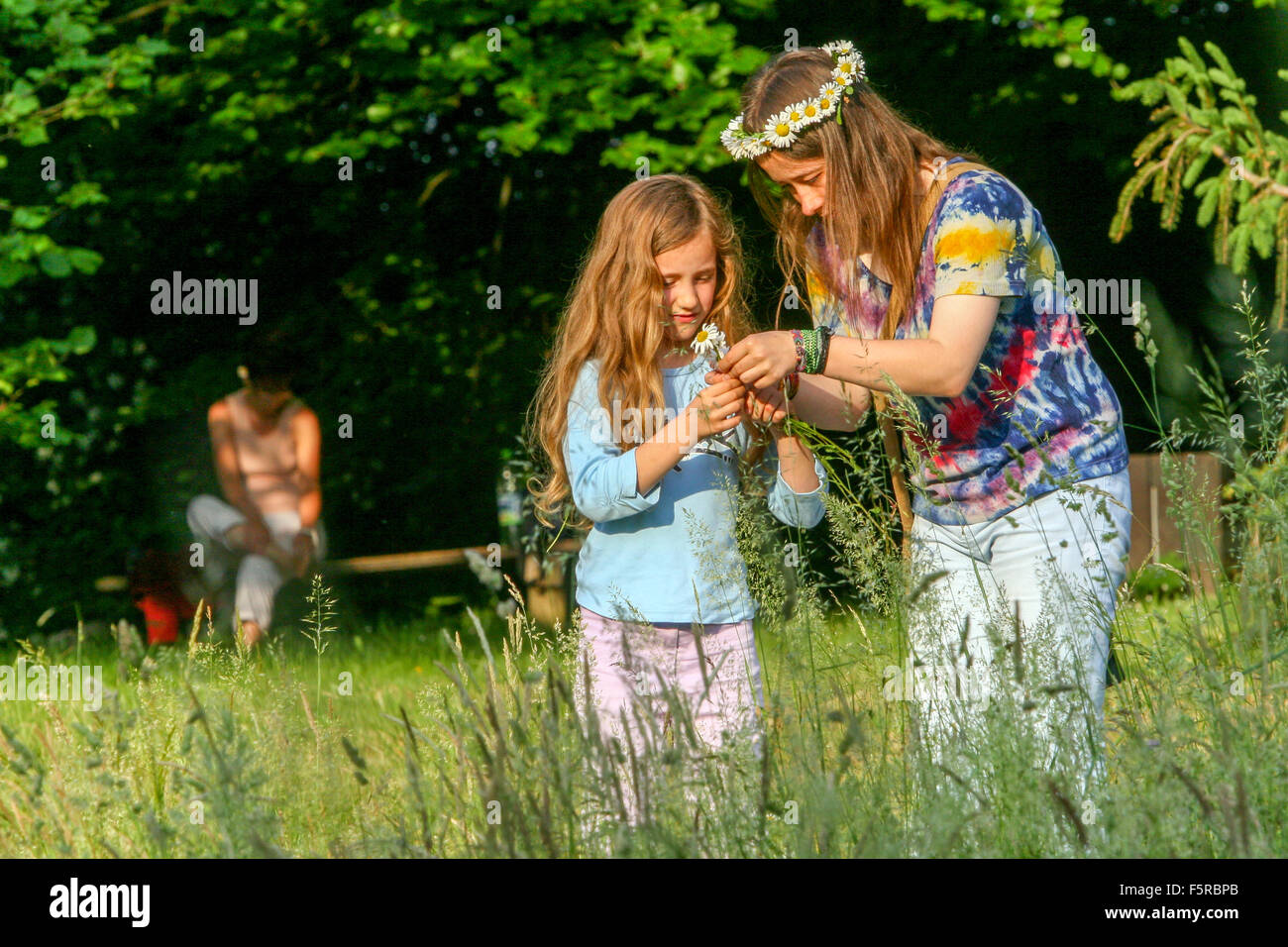 Due ragazze che fanno la corona di testa a Meadow Foto Stock