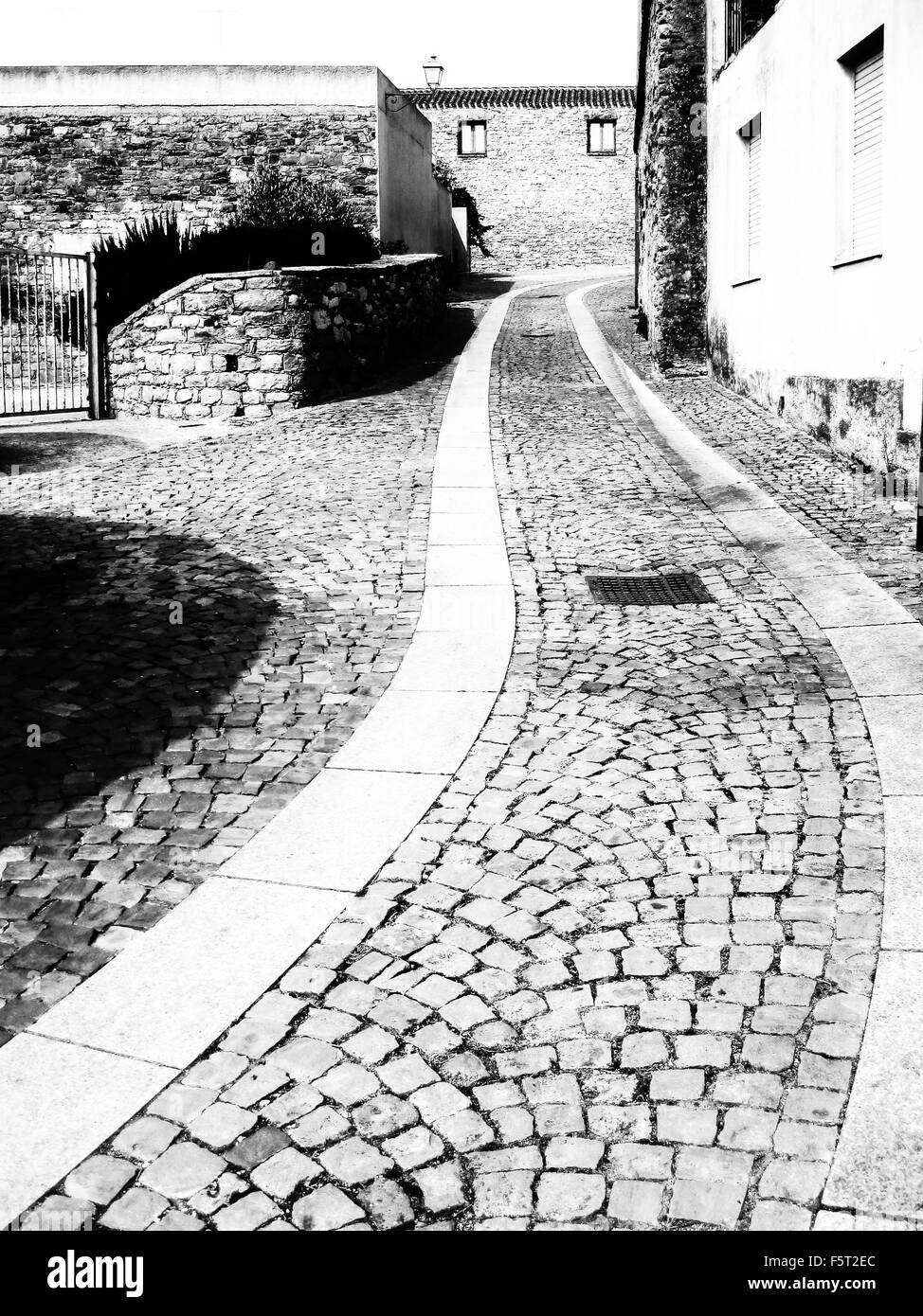 Vecchia strada in salita. Pittoresca strada di pietra in uno storico disctric nella città sarda Foto Stock