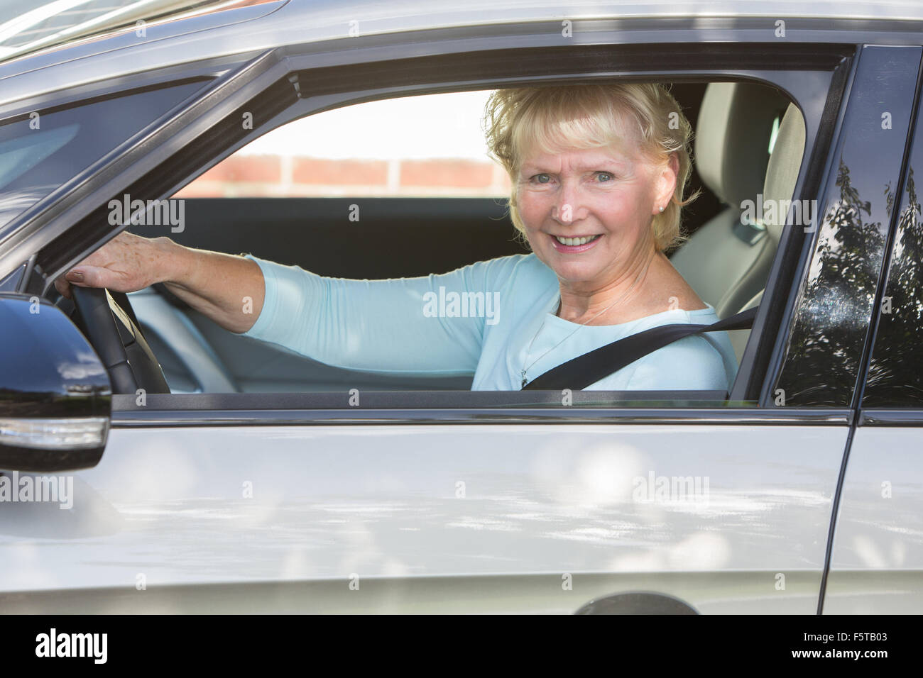 Ritratto di sorridere Senior donna alla guida di auto Foto Stock