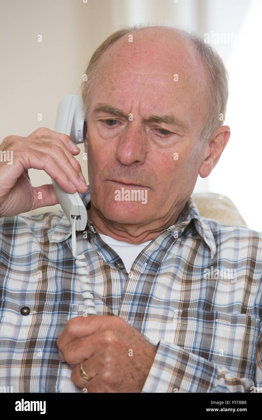Preoccupato Senior UOMO Rispondere Telefono in casa Foto Stock