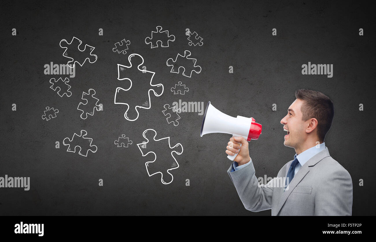 Happy businessman in tuta parlando al megafono Foto Stock