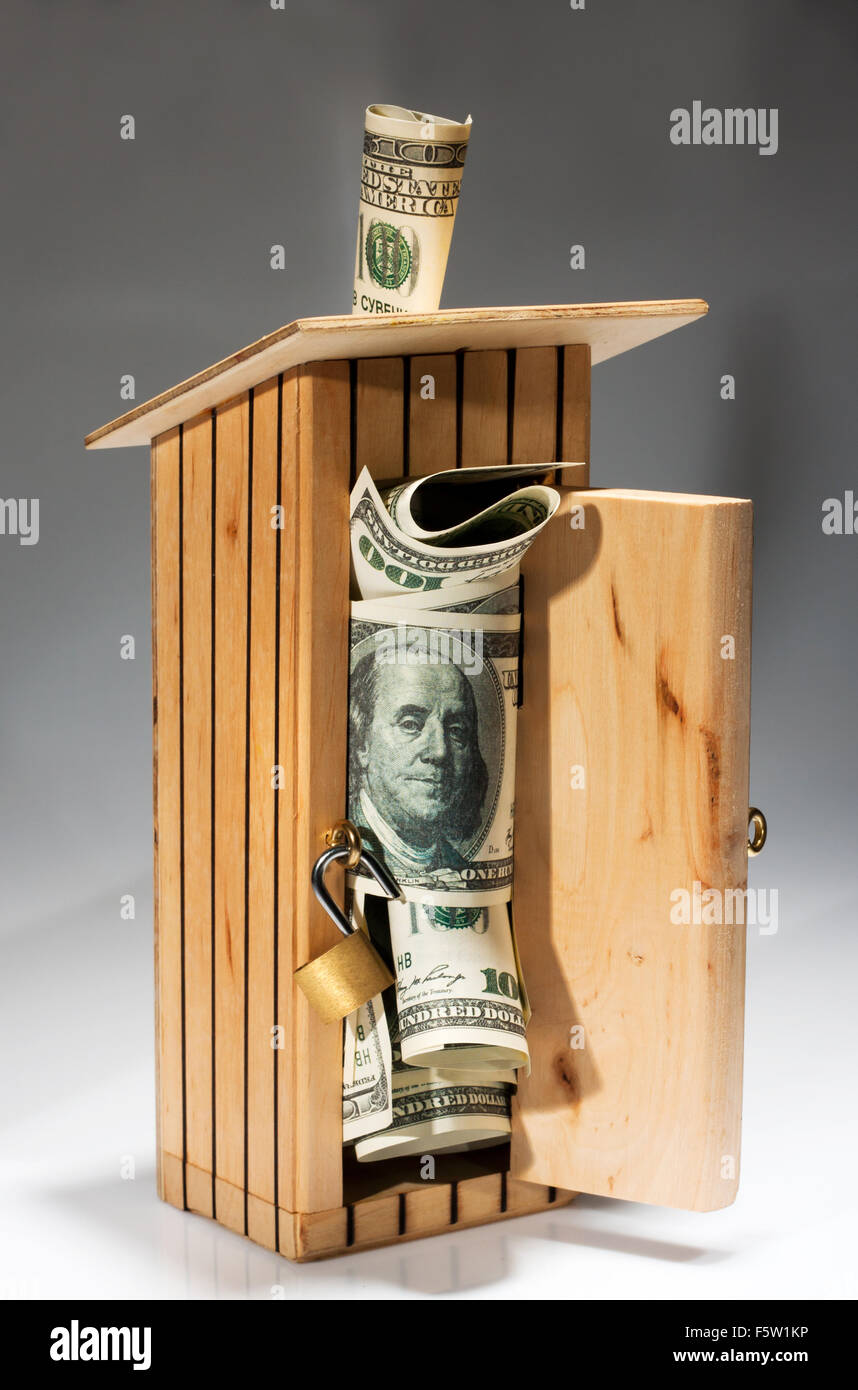 In legno in stile wc salvadanaio pieno di denaro Foto Stock
