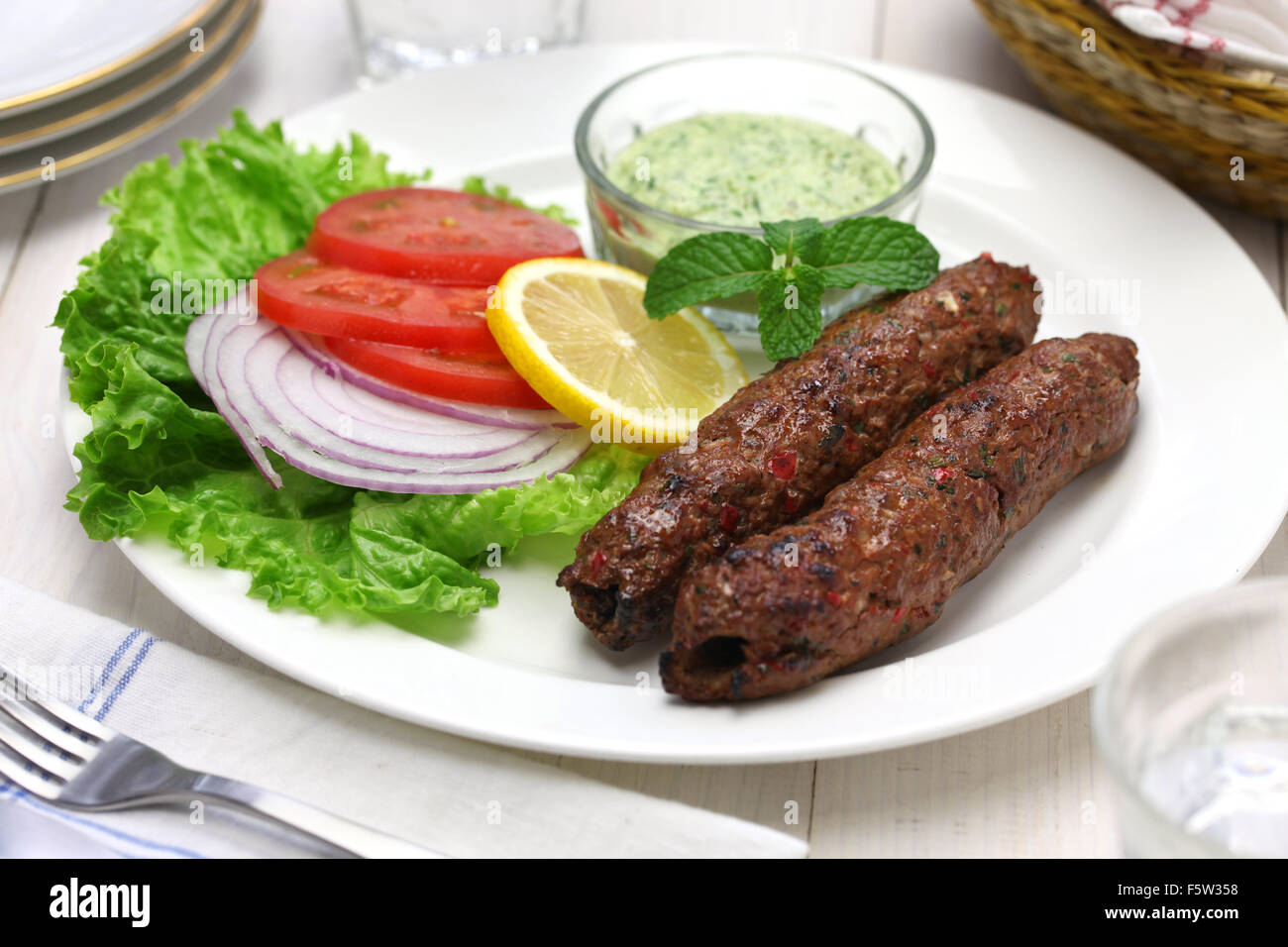 Carni di montone seekh kabab con chutney di menta isolati su sfondo bianco Foto Stock