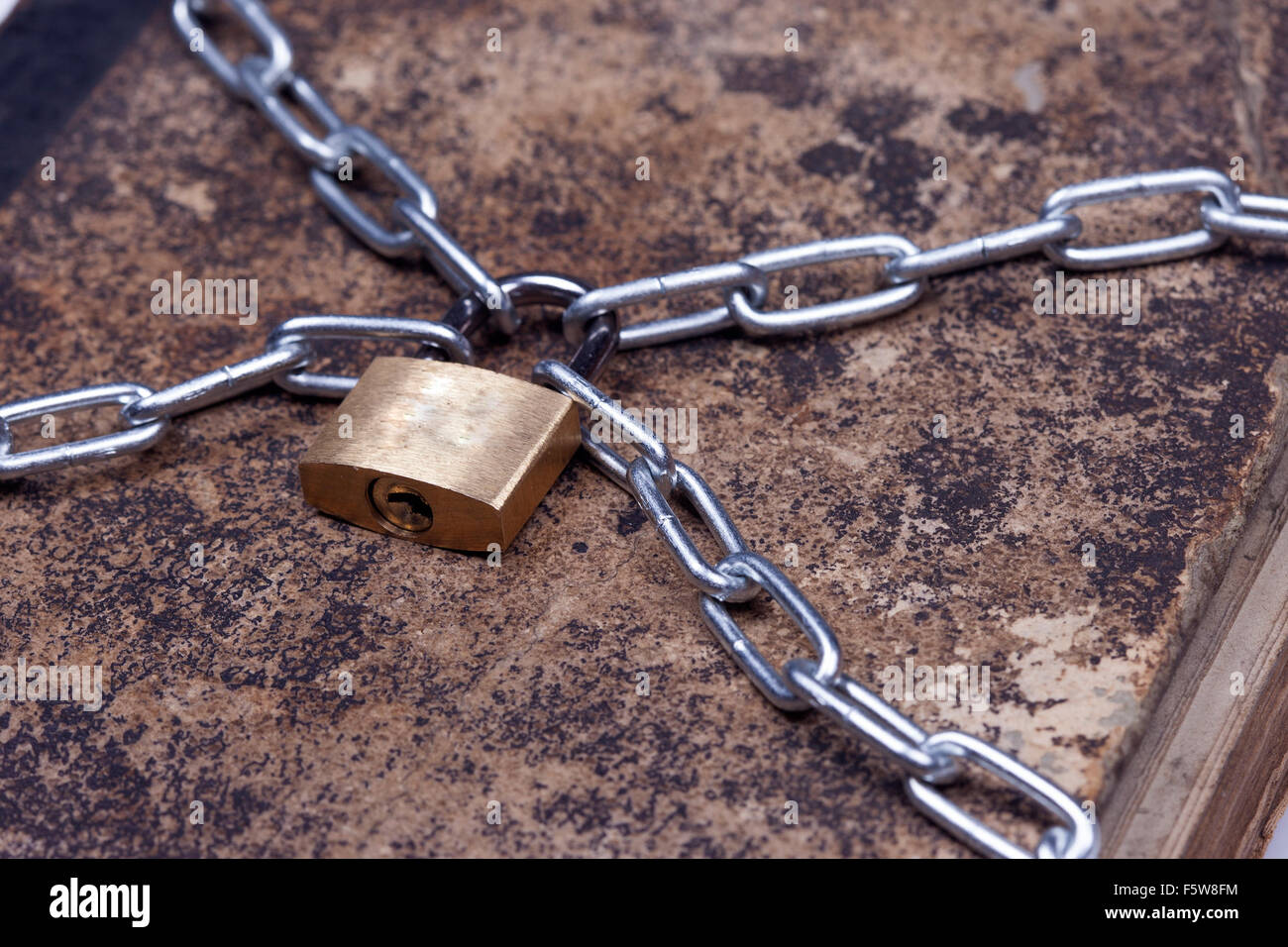 Vecchio vestito di stracci vintage prenota bloccare con catena isolato sfondo bianco Foto Stock