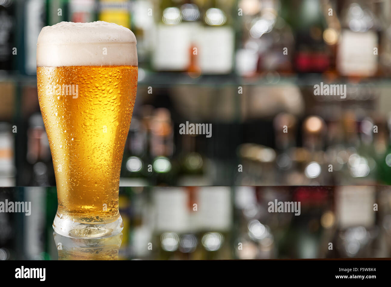 Bicchiere di birra chiara sulla barra di vetro contatore. Foto Stock
