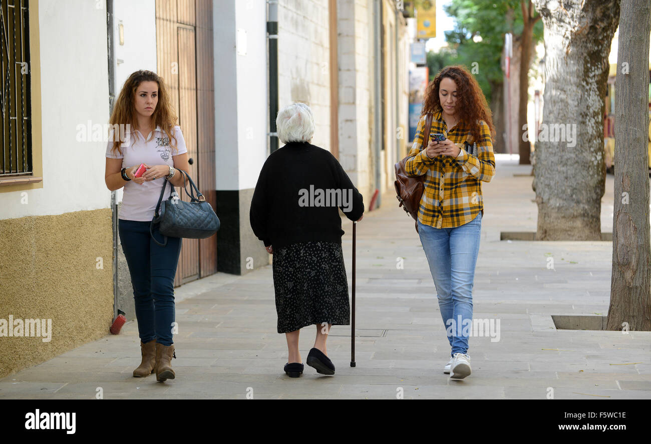 Donna anziana signora camminando tra due ragazze in Ubeda Spagna Foto Stock