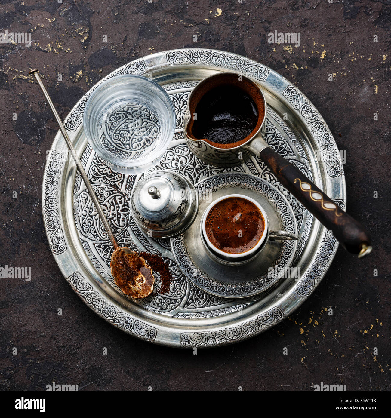 Il caffè turco in POT del caffè e acqua fredda sul vassoio d'argento nero su sfondo di pietra Foto Stock
