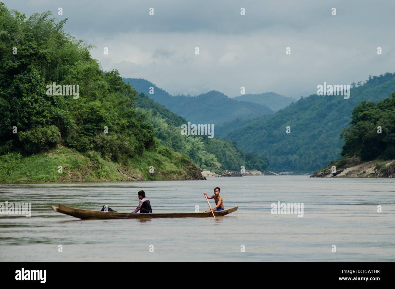 I pescatori locali paddling una barca lungo il fiume Mekong Foto Stock