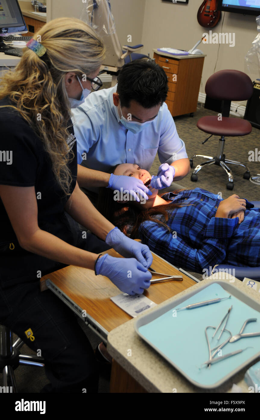 Un ortodontista è un tipo di dentista specializzato di raddrizzare i denti storti. Qui con assistente e il paziente in ufficio. Foto Stock