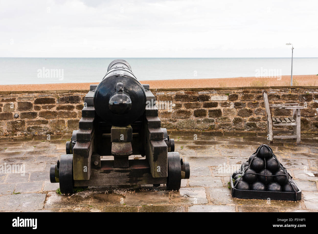Inghilterra, trattativa Castello Tudor. 32-punded cannon, 'pattern Blomfield gun' sulla parete esterna, sottolineando al mare con la pila di palle di cannone. Pioggia, nuvoloso sk. Foto Stock