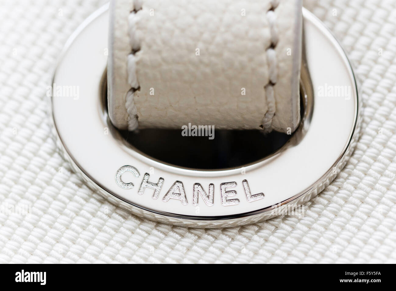 Chanel borsa designer. Close up di bianco con metallo argento Chanel nome circolare metallica di protezione del foro per la maniglia di trasporto. Foto Stock