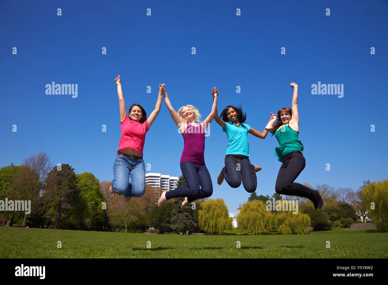Felice quattro giovani donne del salto in aria Foto Stock