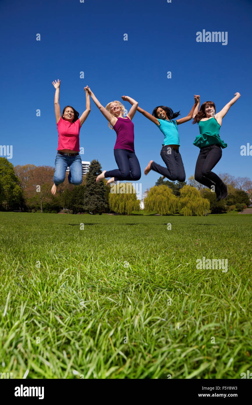 Felice quattro giovani donne del salto in aria Foto Stock