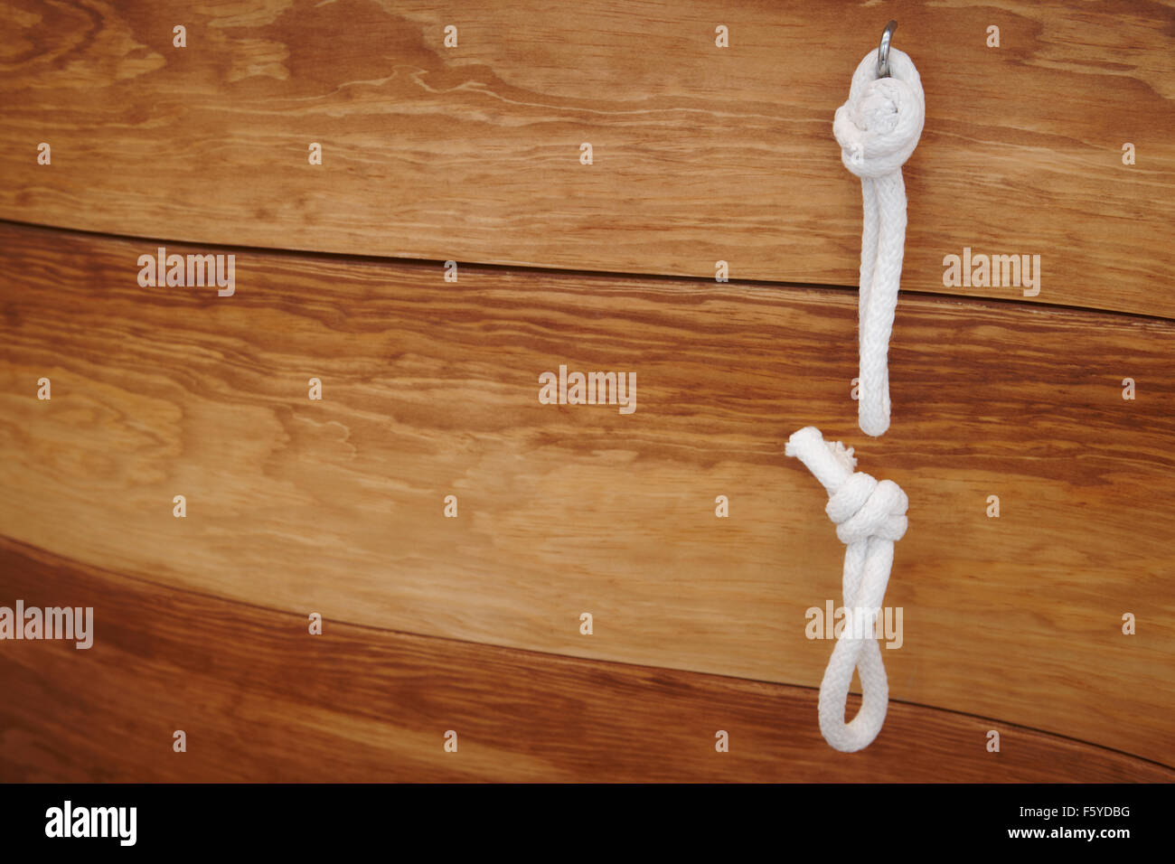 Nodi legati appeso su uno sfondo di legno spazio di copia Foto Stock