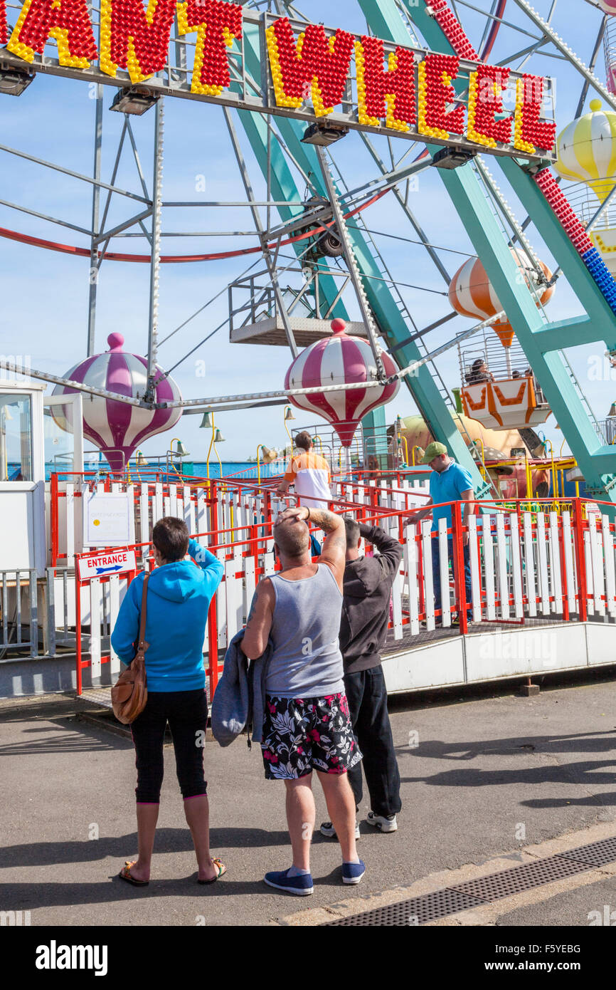Holiday Maker in un mare fairground ride. Persone che guardano la Ruota Gigante a Pleasure Beach, Skegness, Lincolnshire, England, Regno Unito Foto Stock