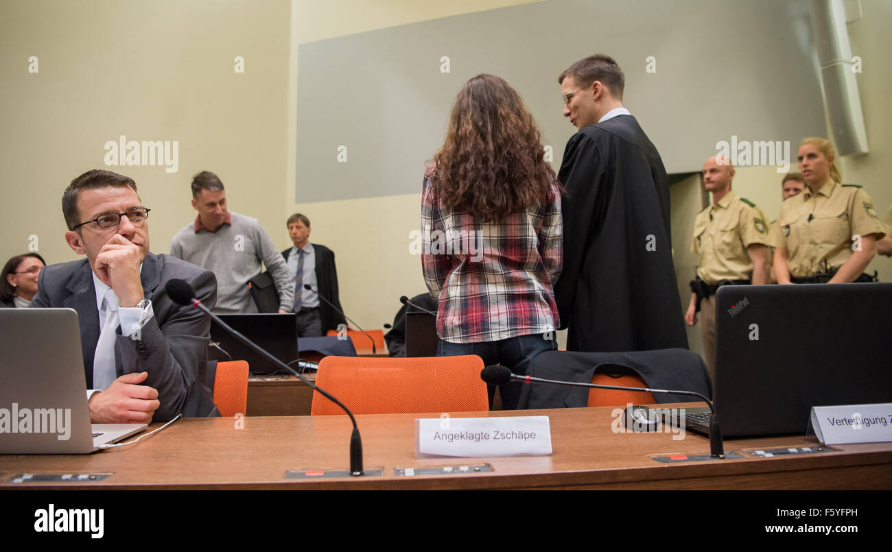 Convenuta Beate Zschaepe (C) parla di uno dei suoi quattro avvocati, Mathias Grasel (R), nelle aule di un tribunale dell'Alta Corte Regionale di Monaco di Baviera, Germania, 10 novembre 2015. Il suo avvocato Wolfgang Stahl si siede a sinistra di lei. Zschaepe è accusato di essere uno dei membri fondatori dell' estrema destra nazionale socialista Metropolitana (NSU) cella di terrore e facce cariche di complicità in omicidio di nove greco e turco immigrati e una poliziotta tra 2000 e 2007, come pure due attentati in aree di immigrati di Colonia e 15 banca rapine. Mentre Zschaepe è atteso a testimoniare dopo il silenzio a Foto Stock