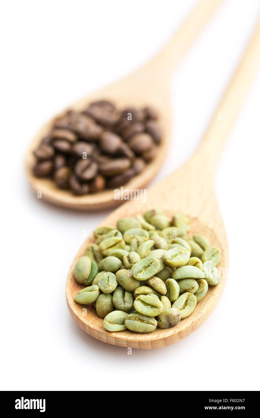 Verde e nero i chicchi di caffè in cucchiaio di legno su sfondo bianco Foto Stock