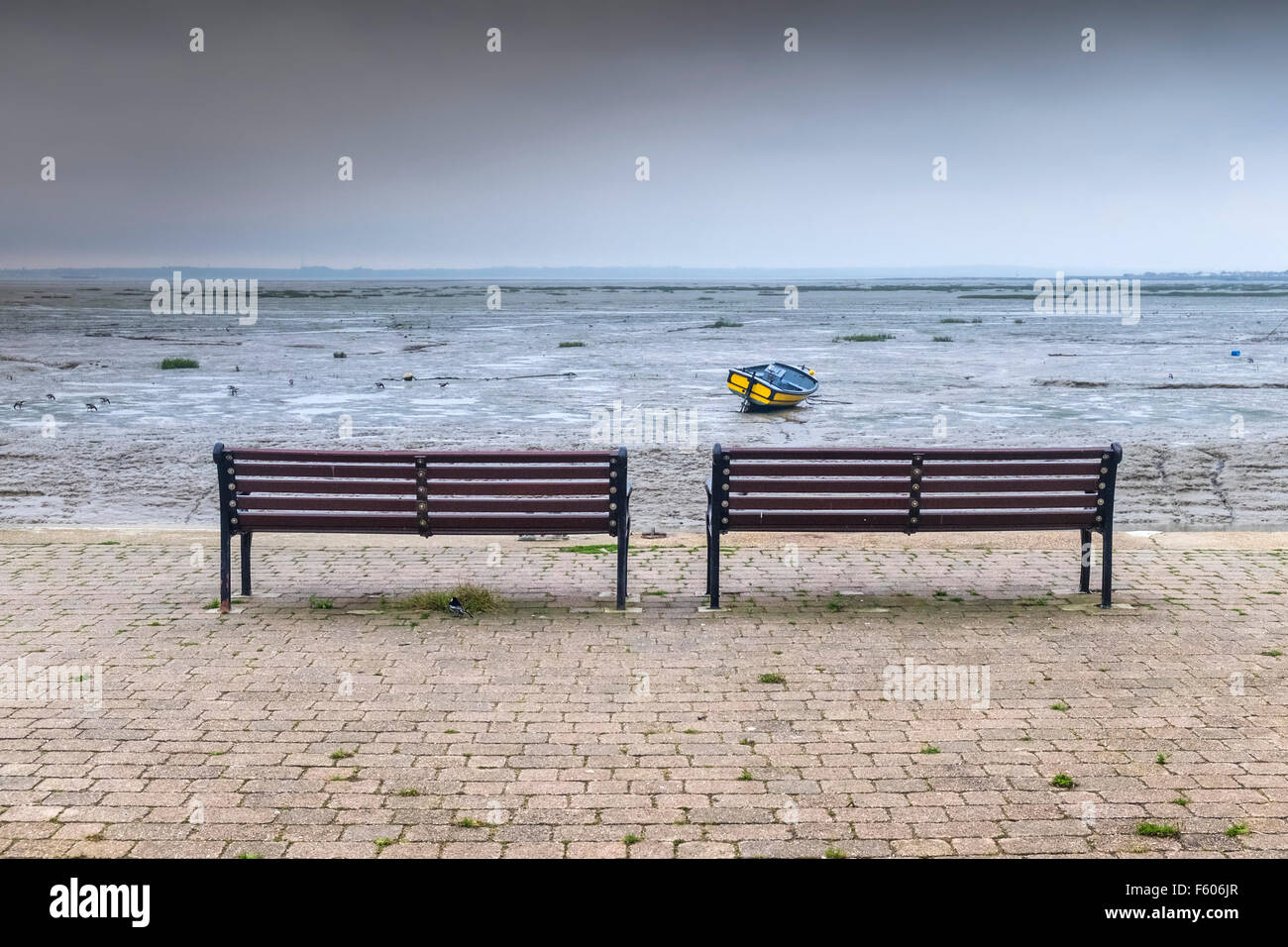 Due panche su un molo che si affaccia sulla Thames Estuary in Essex. Foto Stock