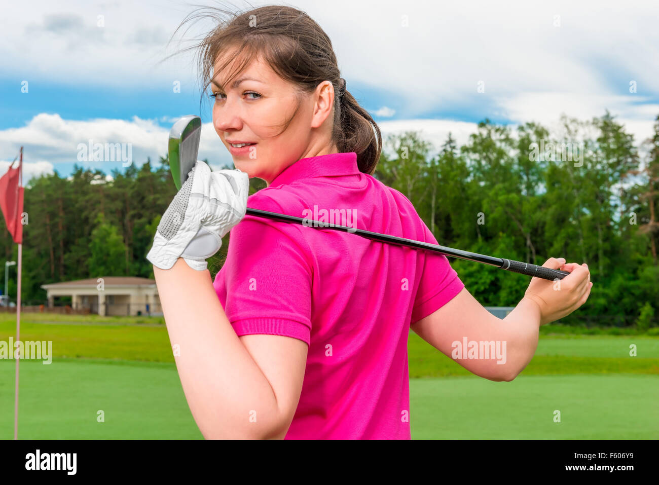 Ragazza con un campo da golf per un club rivolto indietro Foto Stock