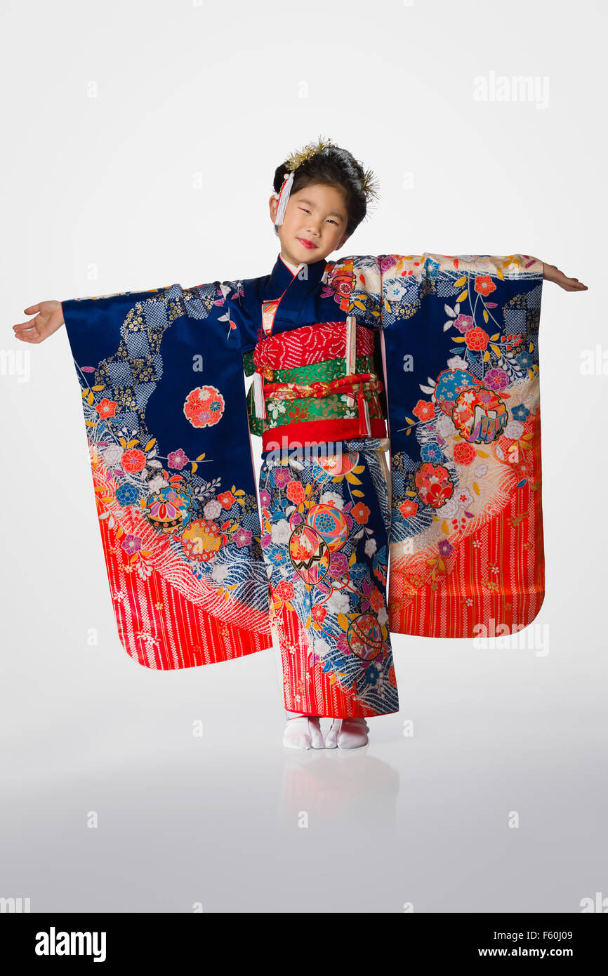 Un simpatico giovane giapponese indossa un kimono su uno sfondo bianco. Foto Stock