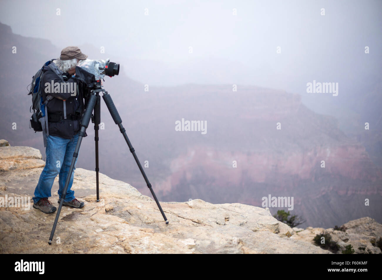 Parco Nazionale del Grand Canyon, Arizona - Un fotografo scatta foto durante la pioggia e nebbia al Grand Canyon di Yavapai Point. Foto Stock