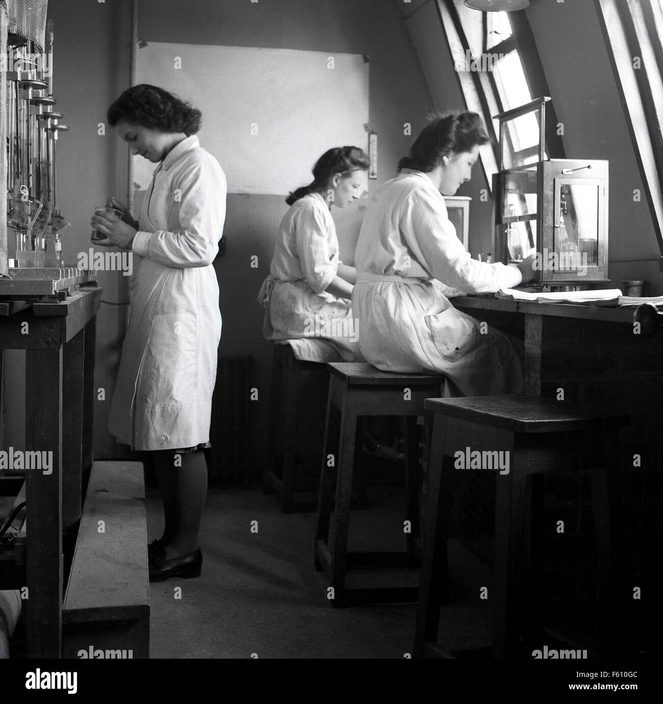 Anni Cinquanta foto storiche, tre giovani femmine studenti adulti che lavorano in un piccolo piano superiore laboratorio. Foto Stock