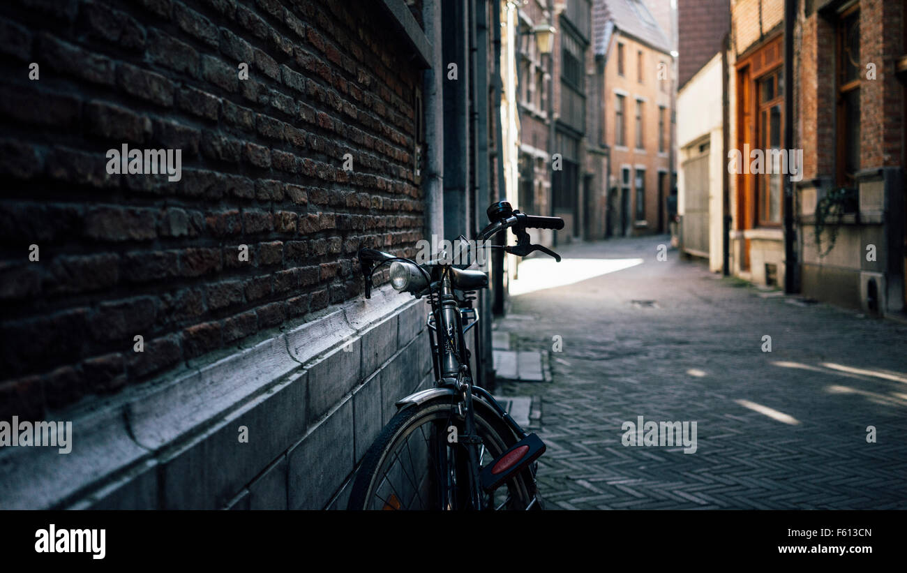 Un vecchio di sedersi e la prego di bicicletta parcheggiata in una corsia di Anversa Foto Stock