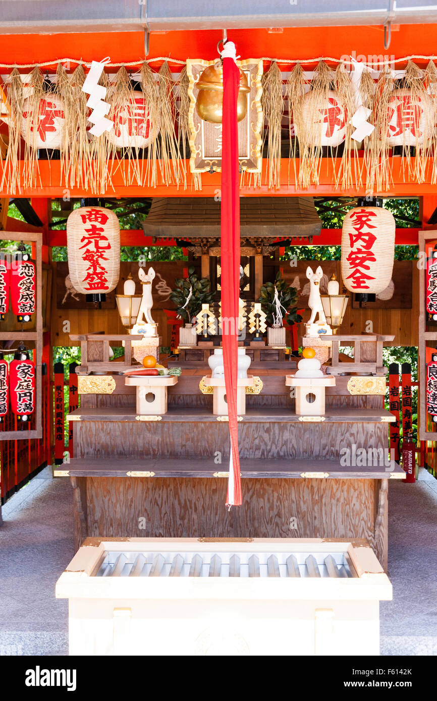 Giappone, Kyoto, Kiyomizu dera tempio. Fox, Kitsune, Inari vermiglio santuario, con campana di corda, suzu, e la scatola di raccolta. Chochin, lanterne di carta appeso. Foto Stock