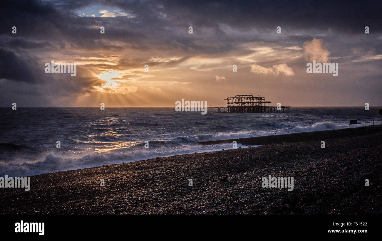 Brighton tramonto con distrutto pier Foto Stock