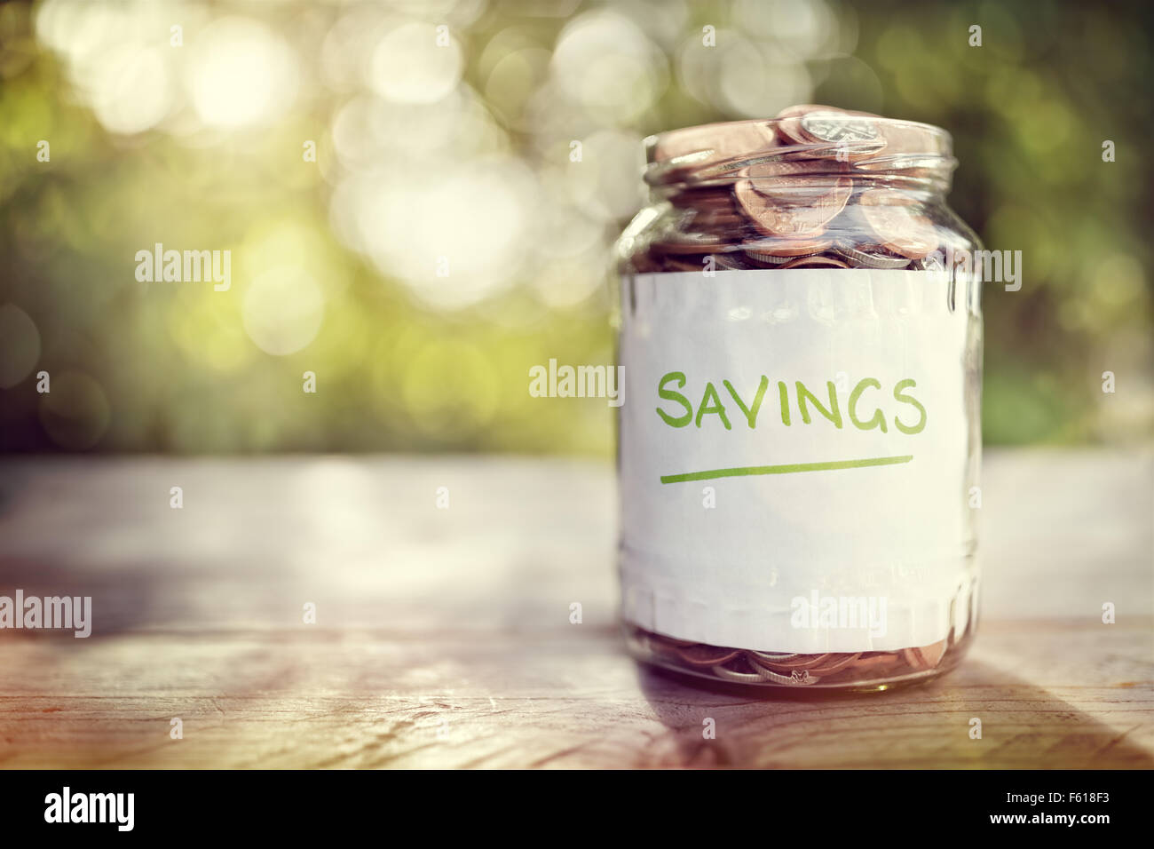 Risparmi soldi jar piena di monete concetto di risparmio o di investimento per una casa, una pensione di anzianità o di istruzione Foto Stock