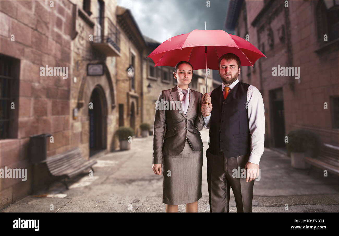 Azienda giovane sotto ombrellone contro l antica strada Foto Stock