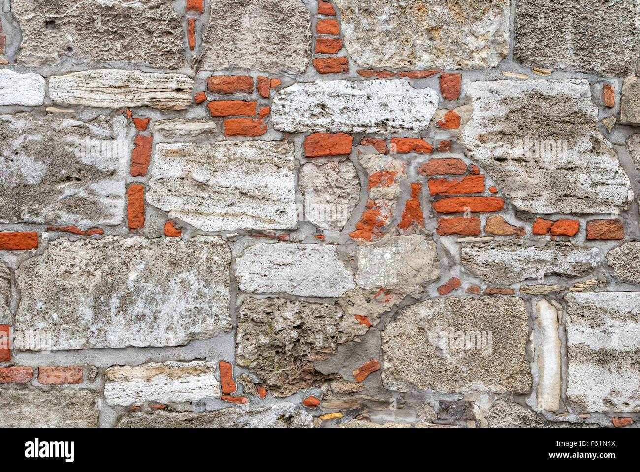 Rotture di vecchia parete di muratura frammento dal rosso bianco mattoni e gesso danneggiato texture di sfondo. Foto Stock