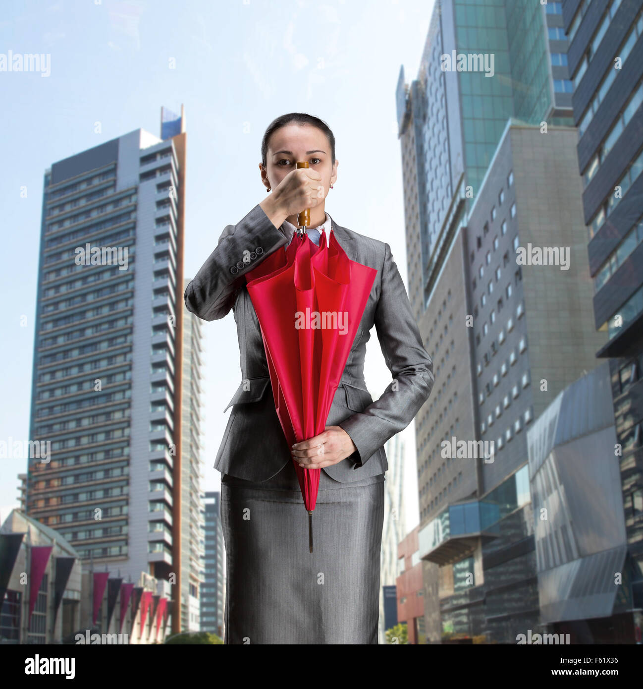 Imprenditrice con ombrello chiuso contro la città Foto Stock