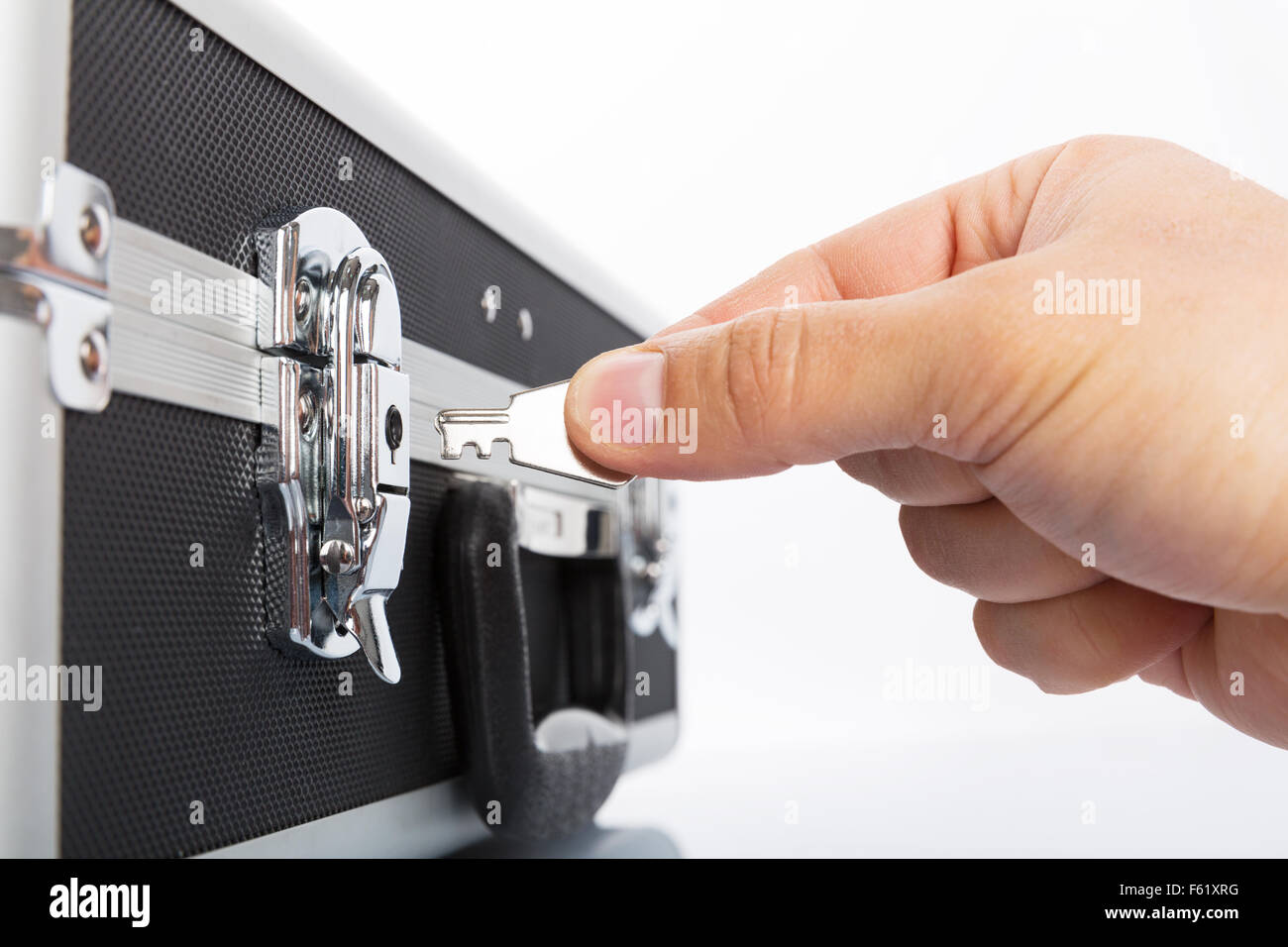 Valigetta metallica per il denaro e la mano con il tasto isolati su sfondo bianco Foto Stock