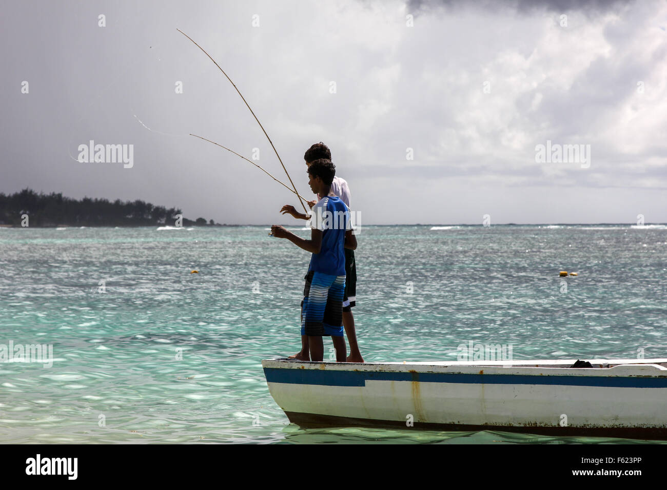 Due ragazzi africani sono la pesca su una barca. Foto Stock