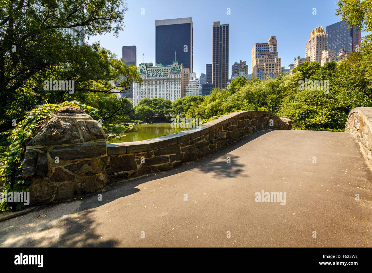 Gapstow Bridge e lo stagno su una mattina di primavera con vista dei grattacieli di Manhattan, al Central Park di New York City Foto Stock