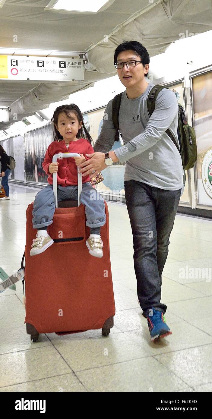 Tokyo, Giappone. 9 Nov, 2015. Un bambino godendo di una corsa sulla valigia attraverso la stazione di Shinjuku a Tokyo, in Giappone. Turismo dall'estero è uno dei pochi settori in crescita l'economia giapponese. 1,61 milioni di visitatori stranieri è venuto in Giappone nel settembre del 2015, che è alto 46,7% in un anno. Il governo giapponese ha fissato un obiettivo per aumentare i visitatori stranieri a 20 milioni nel 2020 e 30 milioni nel 2030. © Rory Merry/ZUMA filo/Alamy Live News Foto Stock