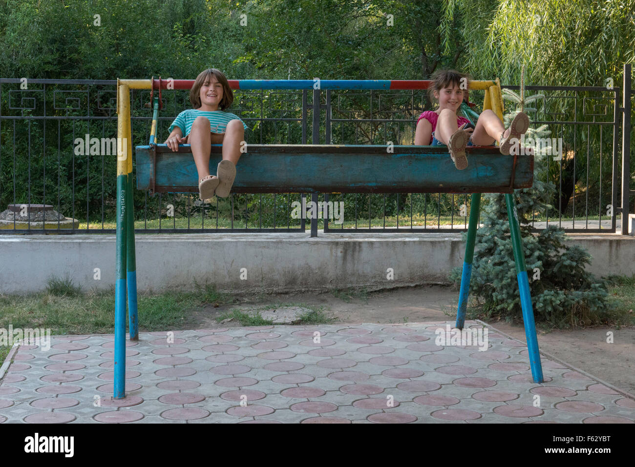 Due ragazze sorridenti su altalena, parco di ricreazione, Dubasari Foto Stock