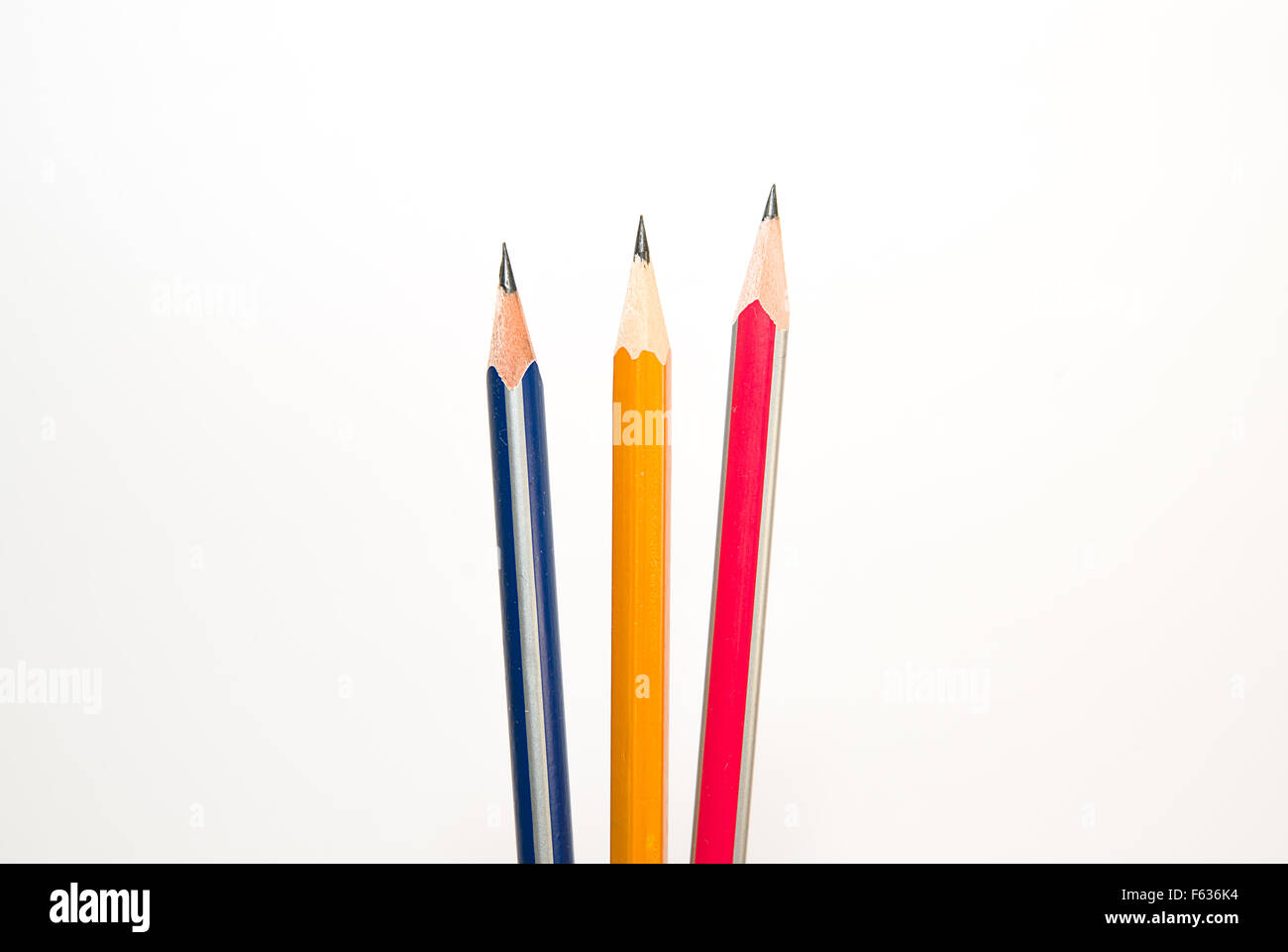 Tre matite di diversi colori su un bianco Foto Stock