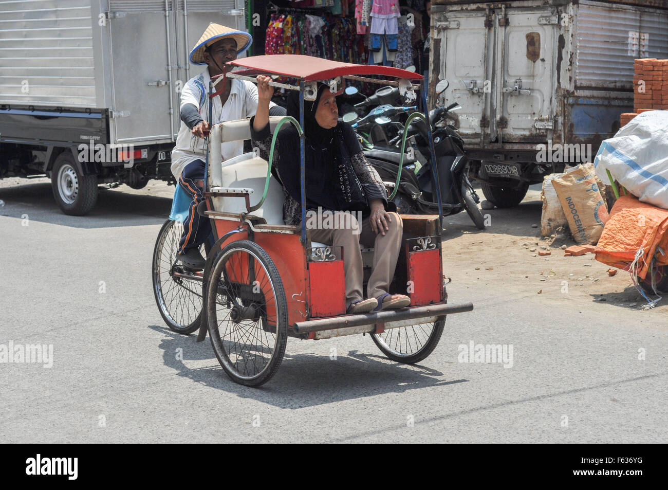 Un pedicab porta una donna in Makassar, Indonesia Foto Stock