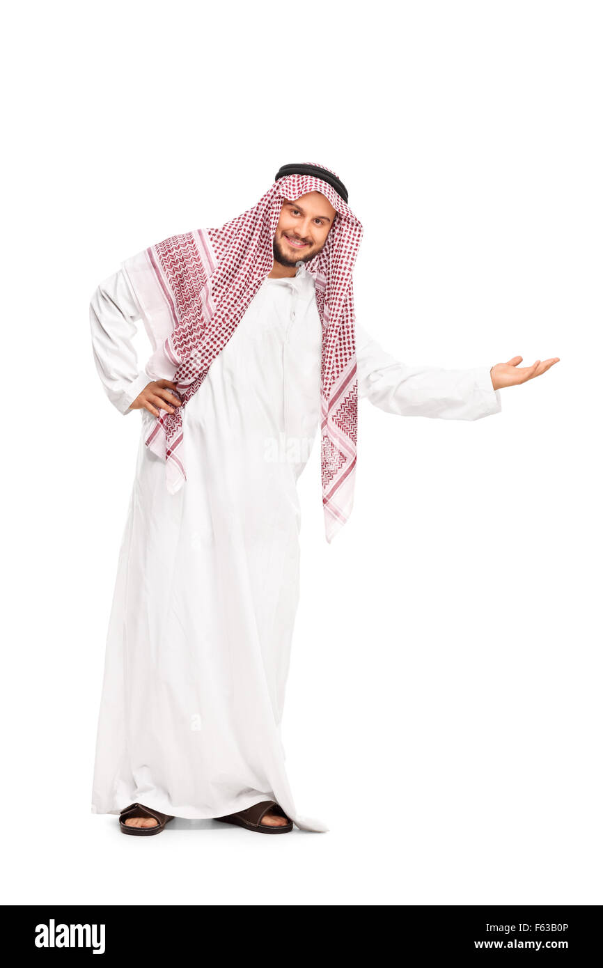 A piena lunghezza Ritratto di una giovane arabo in una veste bianca e il velo a scacchi gesticolando con la mano e guardando la telecamera Foto Stock