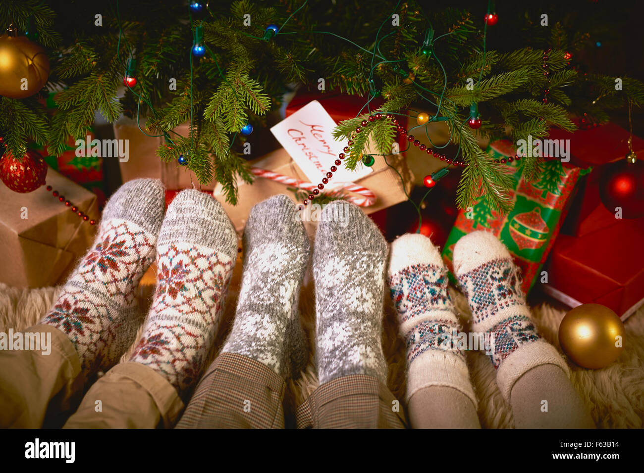 Piedi di uomo, donna e bambino in calze da albero di Natale Foto stock -  Alamy