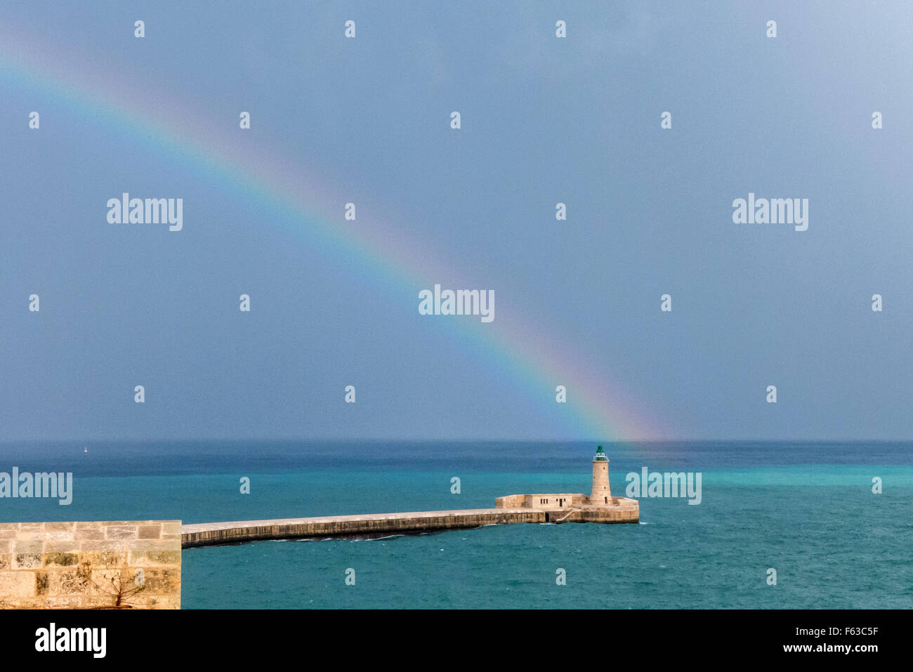 Rainbow sopra il faro del porto di La Valletta a Malta. Foto Stock