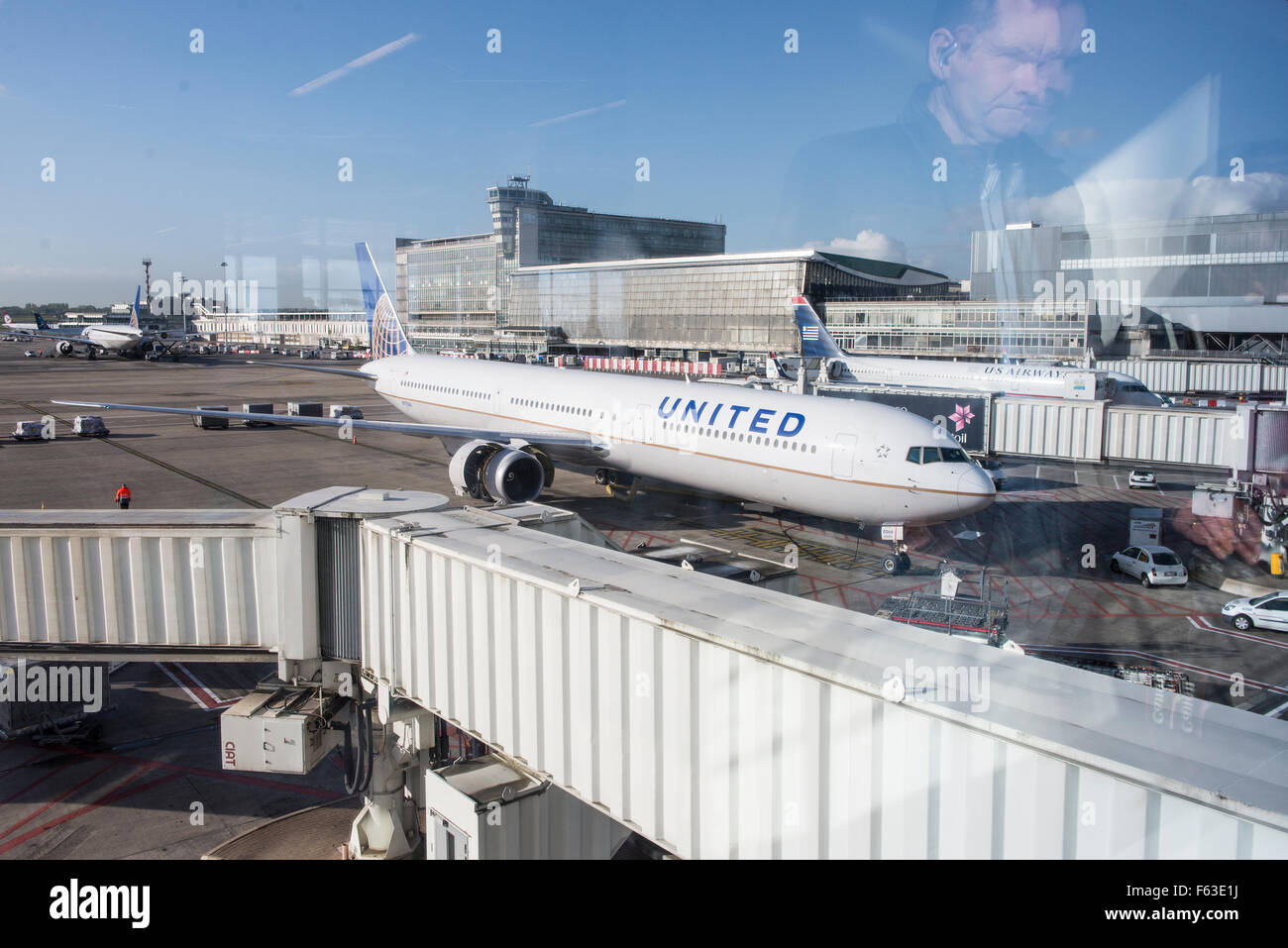 Uomo che guarda attraverso la finestra terminale per aereo Boeing 767-424(ER) con registrazione N77066 della United Airlines a Bruxelles Airpo Foto Stock