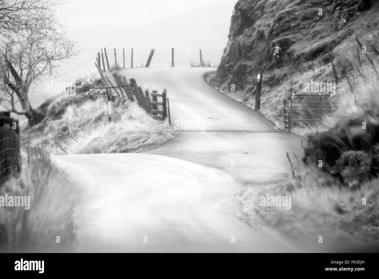 Vista dal parabrezza dell'auto che guida lungo Tregaron Mountain Road , Mid Wales UK in autunno in monocromia - concetto di tempo di decisione su o giù Foto Stock
