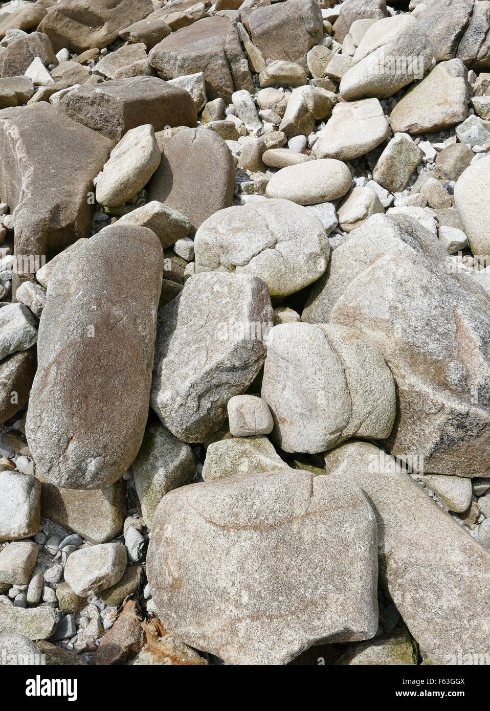 Grandi massi di granito e rocce vicino a una spiaggia a riva. Foto Stock