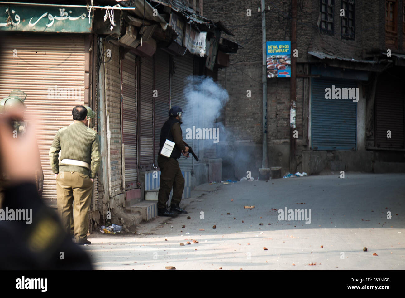 Un indiano poliziotti di incendi a gas lacrimogeni a manifestanti del Kashmir durante scontri nella vecchia Srinagar, Indiano Kashmir amministrato. Foto Stock